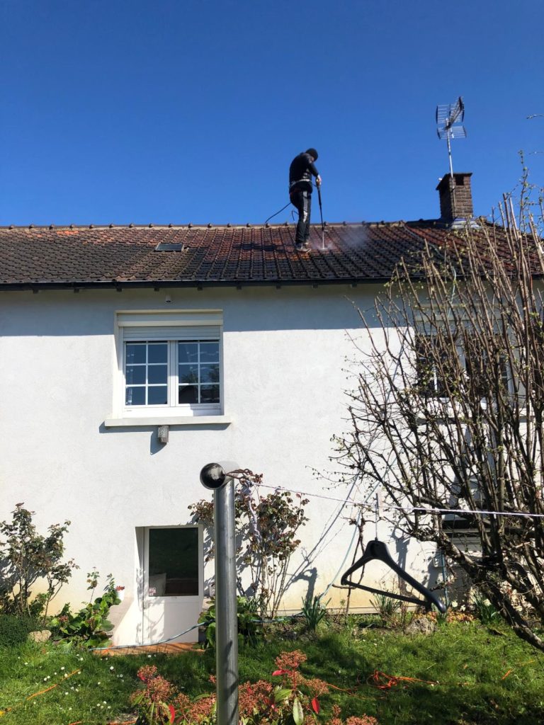 Homme nettoyant un toit